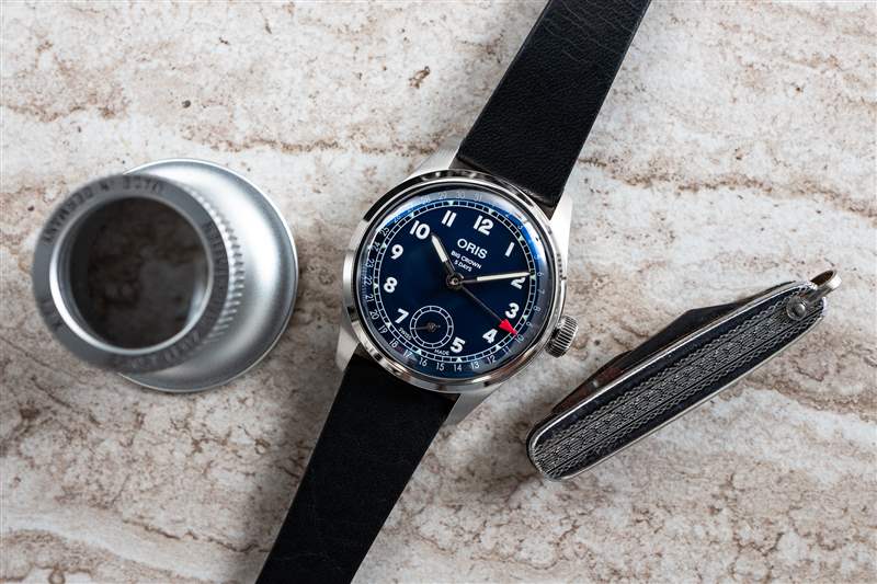 桌子上放著一臺 Oris BC 403，還有放大鏡和小折刀。